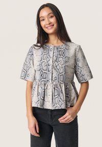 Haut peplum à manches courtes en imprimé serpent, présentant un schéma de couleurs gris clair et noir, un tissu texturé et une fermeture à boutons sur le devant.