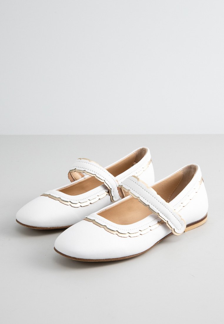 Ballerine bianche in pelle con bordo scallop e una fascia larga sulla parte centrale del piede. Suola piatta e punta rotonda. Design semplice e minimalista.