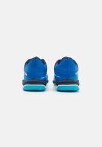 Pantofi sport albaștri cu partea superioară din plasă, guler căptușit și talpă contrastantă de culoare teal. Prezintă tălpi din cauciuc rezistente, concepute pentru aderență.