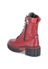 Red leather ankle boot with a textured finish, zipper closure, lace-up front, and rugged black rubber sole. Features branding on the side.
