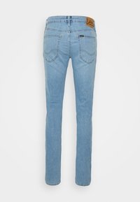 Jeans de pierna recta en un azul claro de tela vaquera. Cuenta con una etiqueta de cuero en la cinturilla y dos bolsillos traseros con detalle de costura.