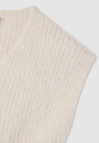 Maglione lavorato a maglia grossa color bianco sporco, design a scollo a V con trama a coste e maniche corte. Materiale morbido visibile nelle cuciture dettagliate.