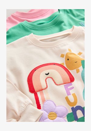 Kaks puuvillast pusa ja üks kaunistatud helekreemjas pusa, millel on vikerkaar, päike, lill ja värvilised tähed erinevates värvides.