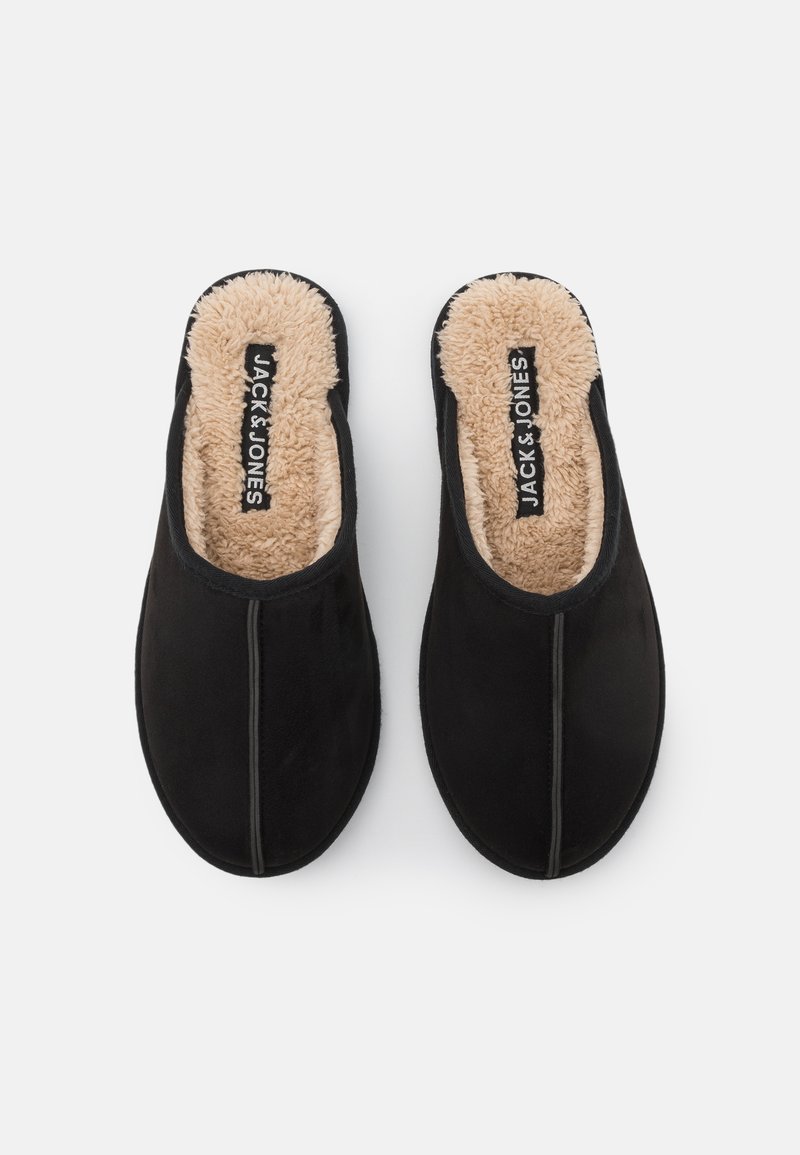 Pantofole nere senza lacci con un morbido rivestimento in pelliccia sintetica beige e un esterno liscio. Progettate con cuciture minime e una forma della punta arrotondata.