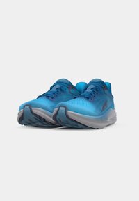 Des chaussures de sport bleu clair avec une tige en maille texturée, une semelle grise contrastante et des accents violets sur les lacets et le logo.