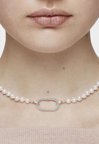 Collar de perlas con un eslabón ovalado central de plata; las perlas son redondas, lisas y blancas, creando un diseño clásico y elegante.
