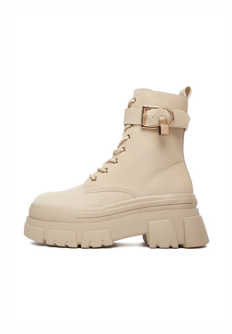 Beżowe botki do kostki z fakturowanej skóry, z sznurowaniem z przodu, paskiem z klamrą i masywną podeszwą na platformie.