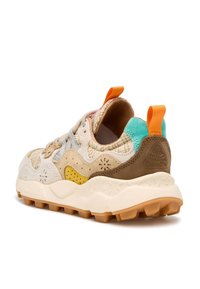 Sneaker featuring a beige upper with textured patterns, yellow and brown accents, orange heel tab, and a rugged outsole for traction.