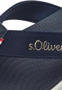 Tumes sinised plätud, millel on tekstuuriga rihmad ja kuldne "s.Oliver" logo. Valge tald koos mustriga jalatoe jaoks, et pakkuda haardumist.