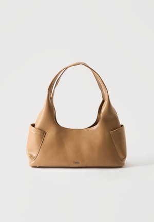 Sac à bandoulière en cuir marron clair avec deux poches latérales extérieures et un petit logo de la marque en métal sur un fond blanc uni.