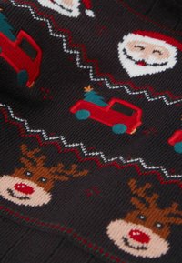 Dzianina z wzorem przedstawiająca uśmiechnięte twarze Świętego Mikołaja, czerwone ciężarówki przewożące choinki oraz uśmiechnięte renifery z czerwonymi nosami na ciemnym tle.