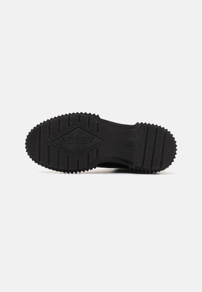 Suela de zapato de goma negra con una superficie texturizada, que presenta un patrón de diamante y bordes aserrados para mejorar el agarre. Logotipo "ADIEV" embosado en el centro.