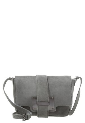 Grå ruskind crossbody-taske med bred skulderrem, rektangulært metal spænde og justerbar skulderrem med spænde-lukning.