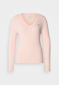 Pull rose clair en maille torsadée avec manches longues et col en V, avec une petite broderie du logo sur la poitrine.