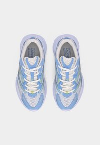 Ζευγάρι μπλε και λευκά αθλητικά παπούτσια Lacoste με πλέγμα στην επάνω επιφάνεια, λευκά κορδόνια και μαλακή σόλα, απεικονιζόμενα από πάνω σε λευκό φόντο.