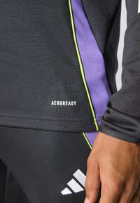 Black athletic shirt with purple and green accents. Features Aeroready branding, fitted design, and textured fabric for moisture management.