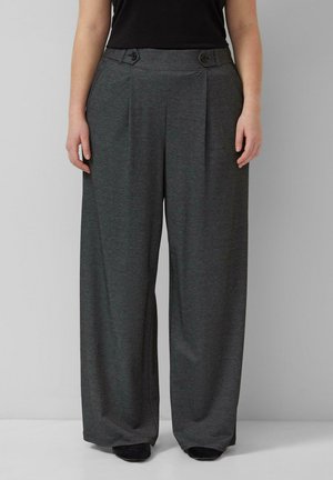 Personne portant un pantalon gris foncé à jambes larges avec des plis sur le devant et des détails de boutons à la taille, associé à des chaussures noires.