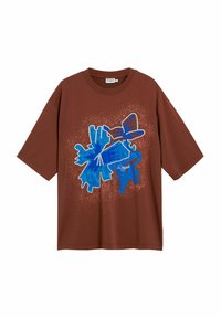 T-shirt en coton marron avec un motif graphique abstrait bleu bien en évidence, avec des accents texturés et une coupe ample.