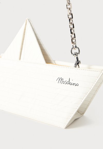 Biały materiałowy torebka w kształcie łodzi, z pionowymi liniami i srebrnym łańcuszkowym paskiem. Logo "Moschino" wytłoczone na przodzie.