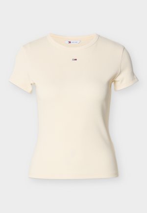 Tricou galben deschis, cu dungi și mâneci scurte, gât rotund și un mic logo brodat cu dungi roșii, albe și albastre pe piept.