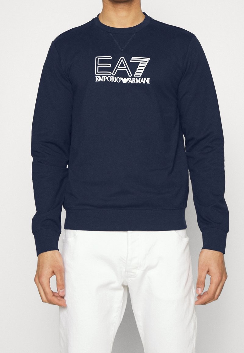 Námořnická mikina s dlouhými rukávy a kulatým výstřihem, s bílým vyšitým logem EA7 Emporio Armani na hrudi. Materiál z bavlněné směsi.