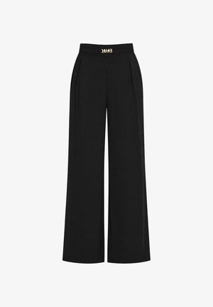 Pantaloni neri a vita alta con ampie gambe, pince frontali e piccolo logo dorato del marchio "LUJO" sulla vita.