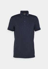 Marinblå smal passform polo skjorta med korta ärmar, tre-knapps placket och vit logotext på kragen och vänster ärm.