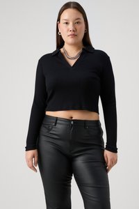 Black, long-sleeve, cropped top with a V-neck and ribbed texture, paired with form-fitting black leather pants. Silver chain necklace.