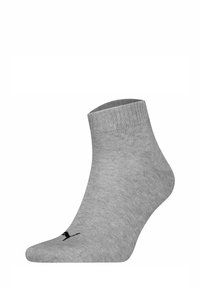 Calcetines tobilleros grises de material acanalado, con un logo negro en el lateral. Diseño clásico con una textura suave.