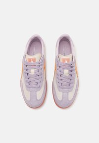 Fialové semišové tenisky s krémovou tkaninou, oranžovými akcenty a texturovanou podrážkou. Mají šněrovací design a polstrovaný vnitřek pro pohodlí.