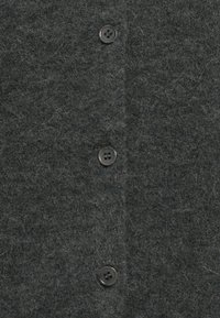 Tessuto di lana grigio scuro con fibre visibili e tre bottoni neri a quattro fori allineati verticalmente.