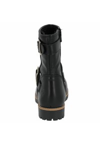 Botín de cuero negro hasta el tobillo con punta redondeada, hebillas laterales y acabado texturizado. Presenta una suela de goma y detalles de costura a lo largo del borde.