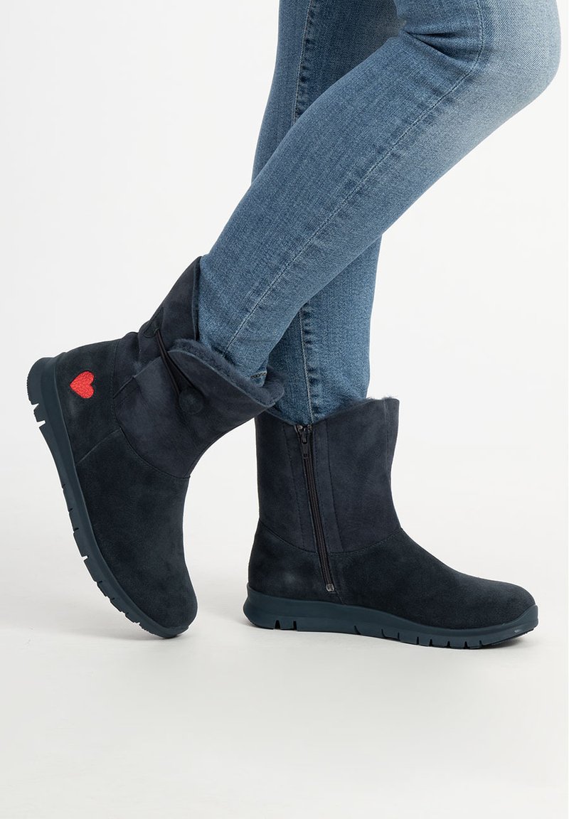 Dunkelblaue Wildleder-Stiefeletten mit Umschlag-Design, seitlichem Reißverschluss und rotem Herz-Akzent. Gummisohle für Halt und Langlebigkeit.