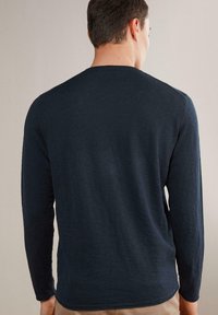 Marintröja med lång ärm och rund halsringning, slät textur och smal passform. Bakvyn visar diskreta sömdetaljer och nederkant.