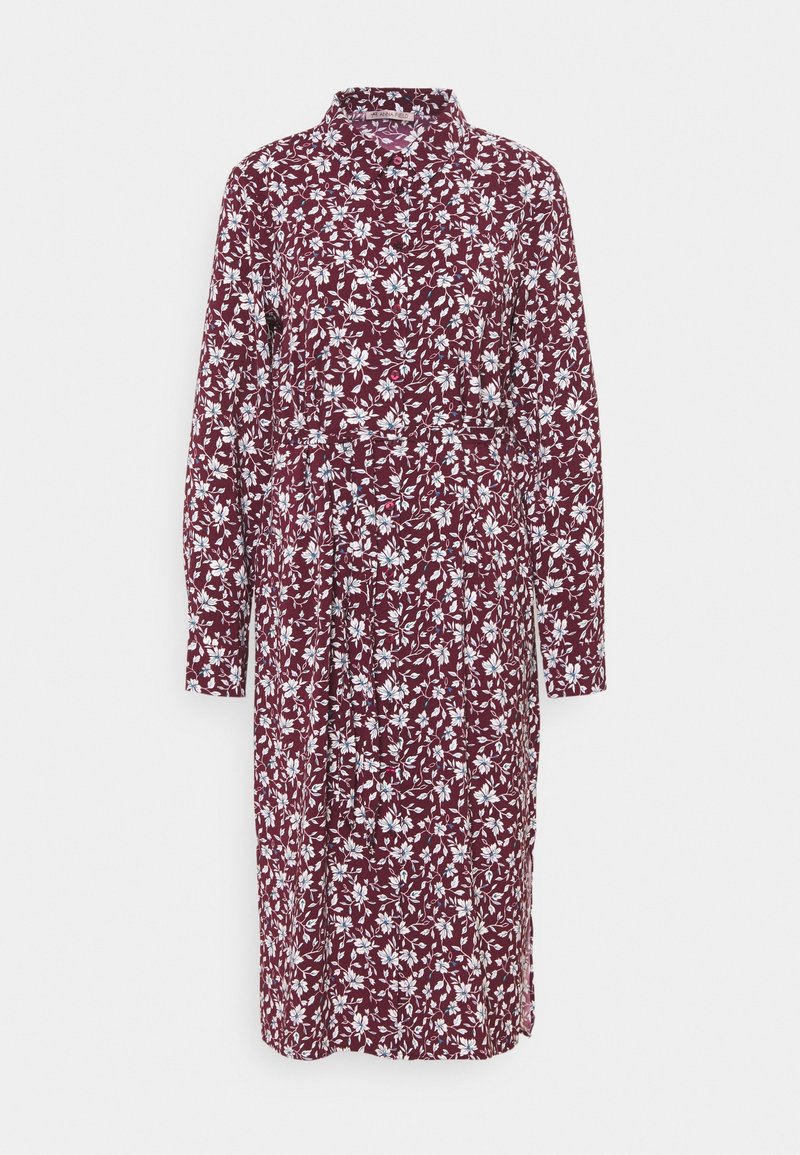 Lila blommig klänning med långa ärmar, knapp-up krage och bälte i midjan. Har ett vitt blommönster över hela. Tillverkad av lättviktsmaterial.