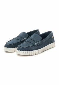 Mocasines de ante azul con diseño de mocasín, que cuentan con suelas de goma blanca y acentos cosidos a lo largo de los bordes. Detalle de marca mínimo presente.