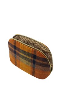 Pochette cosmétique en tartan de laine aux tons orange et marron avec une fermeture éclair dorée et une doublure intérieure à motifs floraux. Forme arrondie.