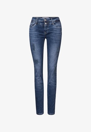 Jeans attillati in denim blu scuro con toppe strappate. Chiusura a due bottoni e design standard a cinque tasche. Tessuto liscio, forma aderente.