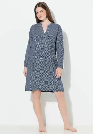Granatowa sukienka z długim rękawem, pełna białego geometrycznego wzoru, z kołnierzykiem typu notch, w luźnym kroju i do kolan. Miękka tekstura tkaniny.