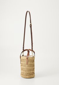 Woven straw bucket bag with brown leather shoulder straps and accents. Features a circular shape with textured detailing and brass hardware.