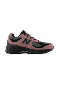 Chaussure de sport basse avec panneaux en maille rose poussiéreux, noir et gris, semelle noire épaisse et logo "N" sur le côté.