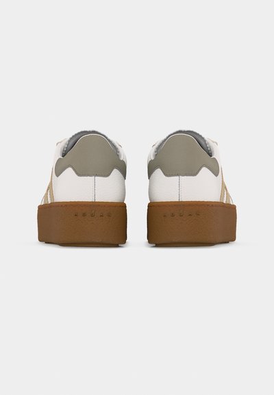 Paire de baskets blanches avec des languettes de talon grises et des semelles épaisses en caoutchouc marron, vues de dos sur un fond uni.