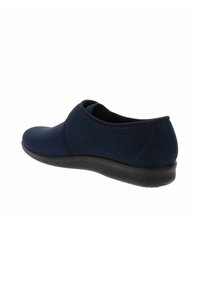 Zapato náutico sin cordones en color marino con punta redondeada y parte superior de malla transpirable. Cuenta con una suela de goma negra texturada para mayor tracción.