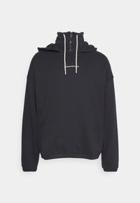 Svart hoodie med hög krage, dragkedja fram och dragsko. Har en liten vit logga på bröstet och ribbade ärmslut.