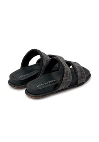 Sandales noires à glissière avec des lanières croisées ornées de strass, une semelle intérieure noire lisse et une semelle texturée pour une meilleure adhérence.