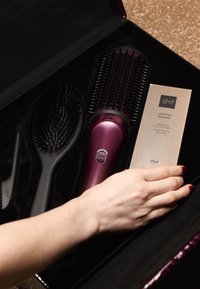 GHD hårstylingset med en lila värmeborste, en svart paddelborste och en volymgivande kräm i en snygg ask.