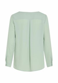 Blusa a maniche lunghe di colore verde chiaro, con una texture liscia, scollatura a girocollo e dettaglio di piega sulla schiena. I bottoni ai polsini delle maniche arricchiscono il design.