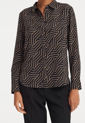 Musta napillinen paitapusero, jossa on beige geometrinen kuvio, pitkät hihat ja jämäkkä kaulus. Valmistettu kevyestä, sileäpintaisesta kankaasta.