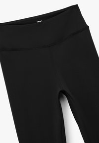 Svarta högmidjade leggings gjorda av texturerat tyg, med en slät midjeband, platta sömmar och en åtsittande design.