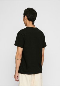 Sort bomulds T-shirt med korte ærmer, rund halsudskæring og en afslappet pasform, med en glat overflade og uden synlige mønstre eller accenter.